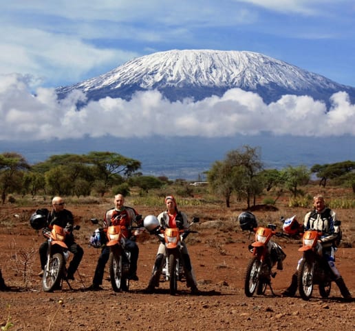Four riders and their motorcycles in front of Mount Kilimanjaro
